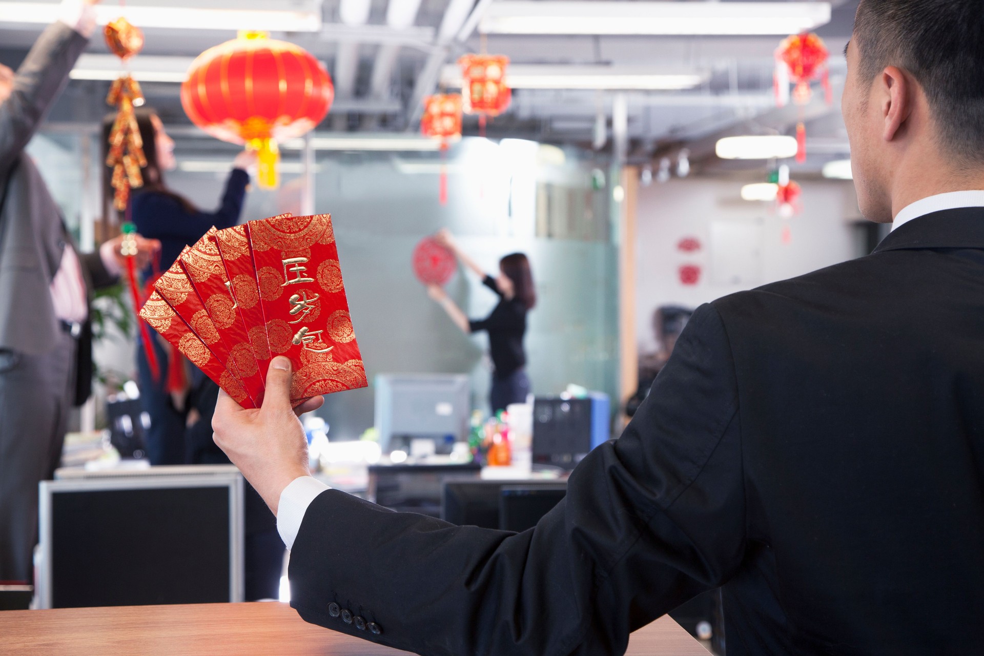 Businessman holding red envelopes for Chinese new year